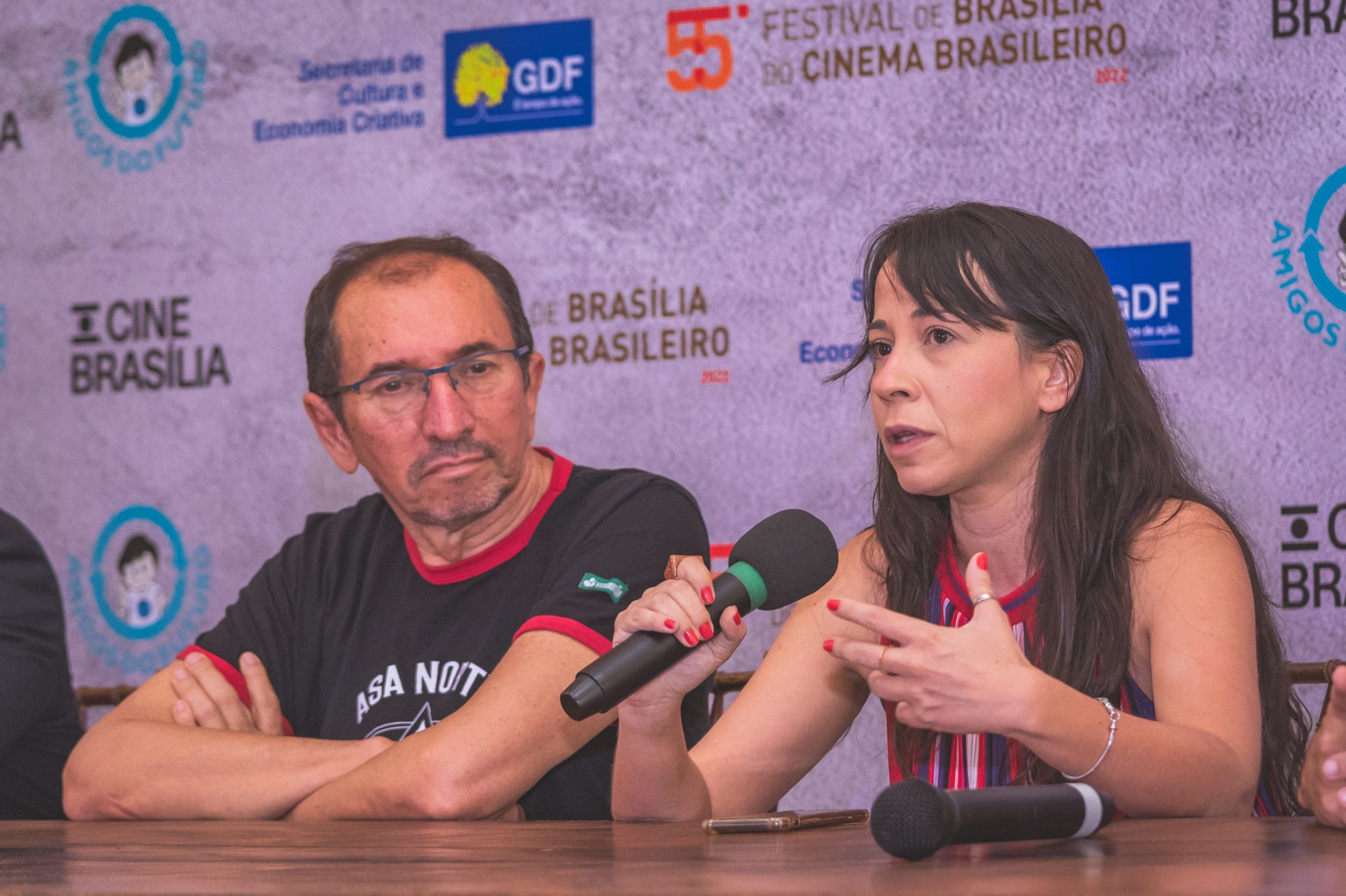 Mulher branca fala ao microfone