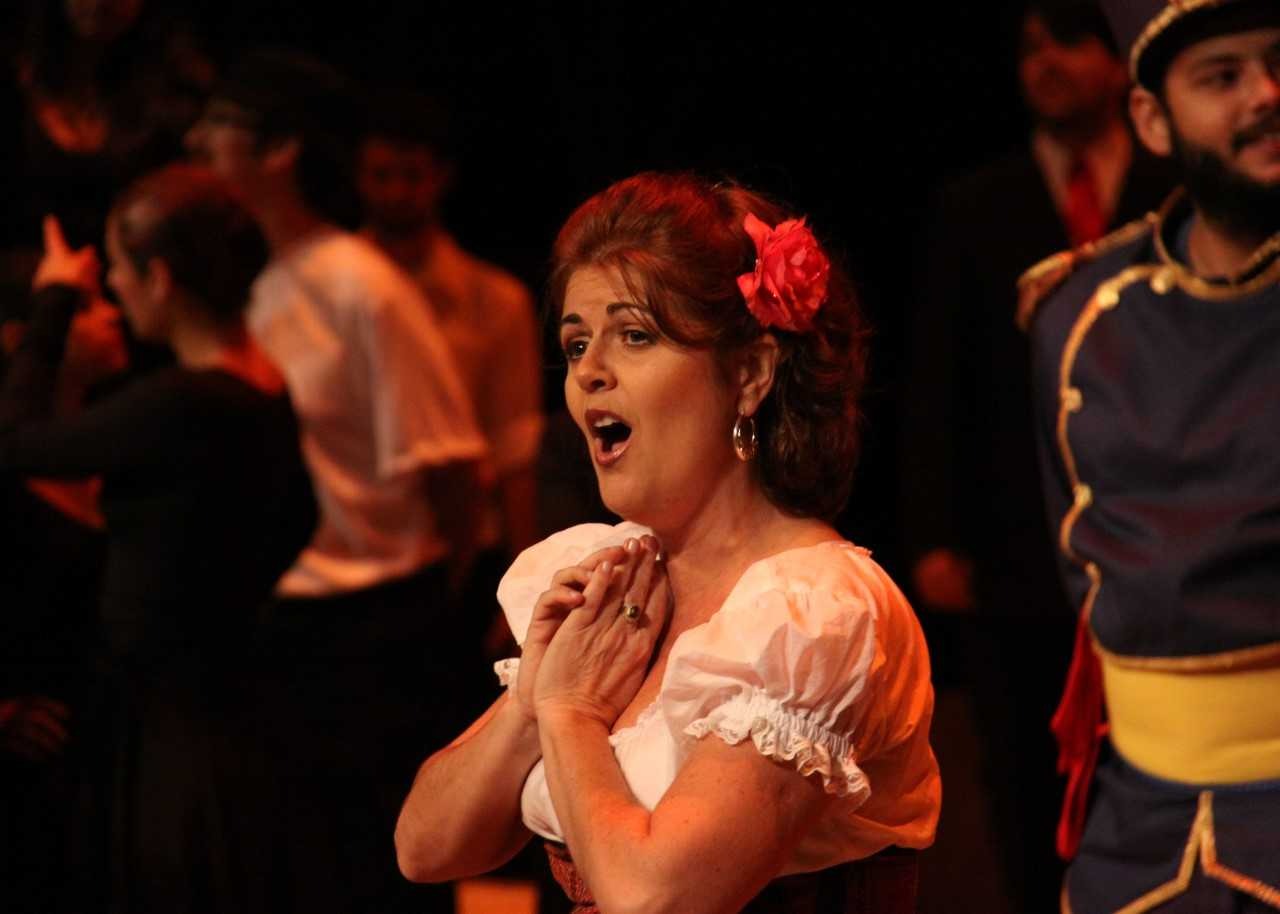 Mulher cantando, com flor no cabelo