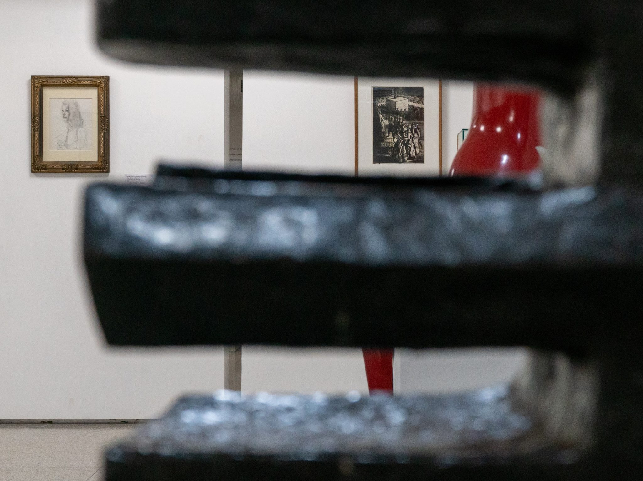 Exposição do acervo do MAB, com quadros de Di Cavalcanti e Portinari em segundo plano, atrás de uma escultura de cor preta