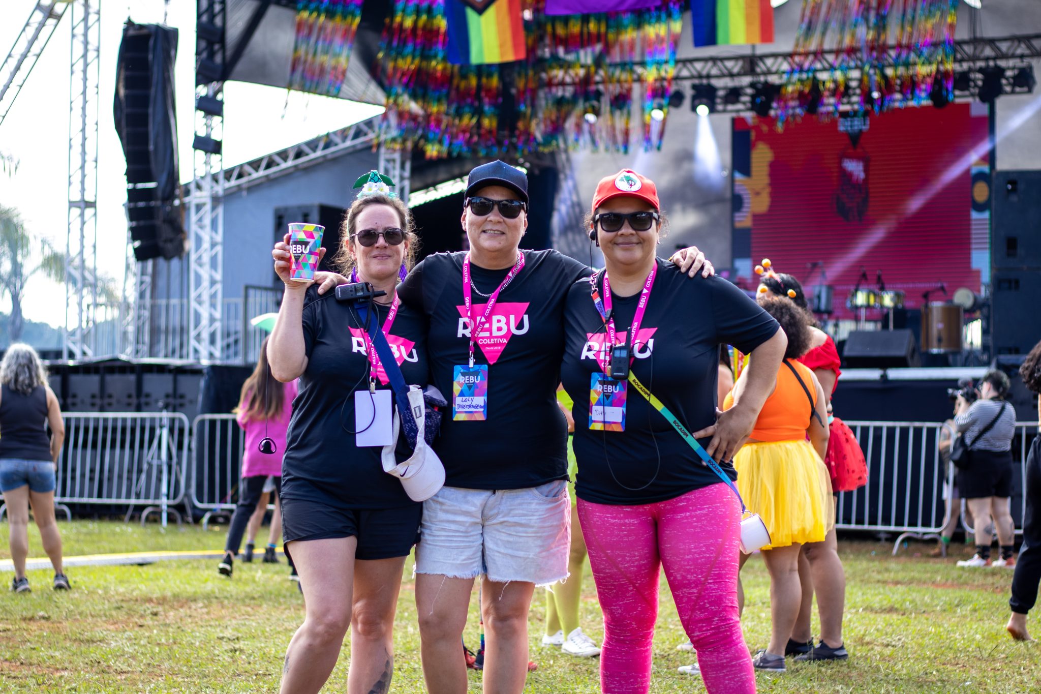 Foto de 3 mulheres abraçadas na frente do palco