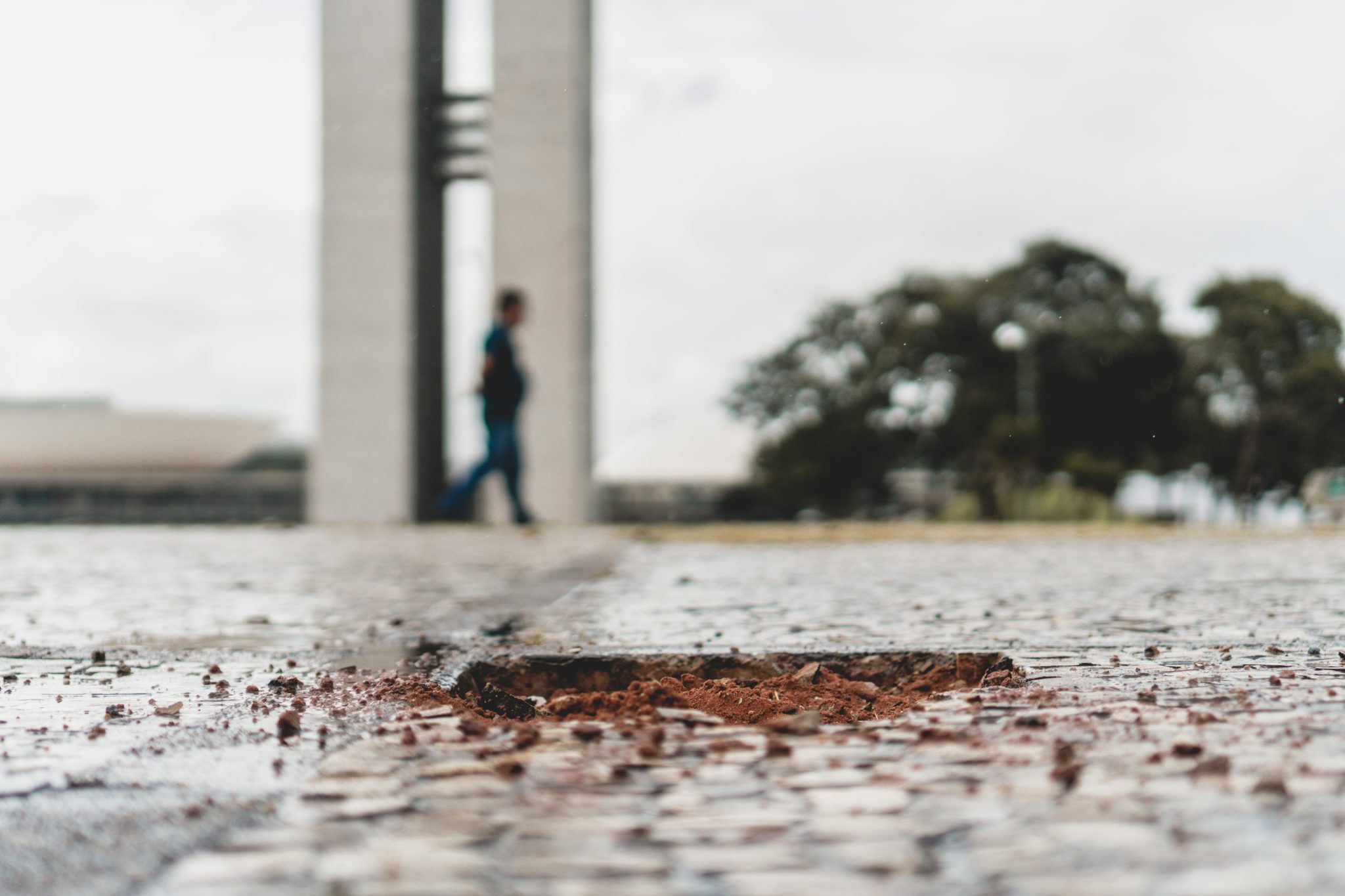 Pedras arrancadas numa praça. Ao fundo, o Congresso Nacional
