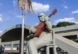 Estátua de cantador nacom violão em mãos, em frente da Casa do Cantador