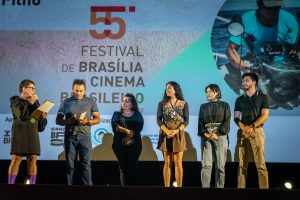 6 pessoas no palco do Cine Brasília, Manoel Messias Filho recebeu homenagem de representantes da ABCV