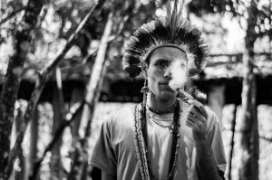 Foto preto e branco de homem indígena fumando