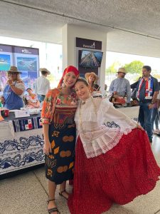 Imagem de 2 mulheres em roupas típicas em frente à barraca do Panamá